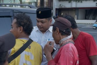 Kader PDI Perjuangan Surabaya, Achmad Hidayat membagikan sembako kepada masyarakat.