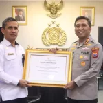Kepala Kantor Imigrasi Kelas I TPI Surabaya, Agus Winarto menyerahkan penghargaan dari Menteri Imigrasi dan Pemasyarakatan Kepada Kapolresta Kombespol, Kombespol Christian Tobing.