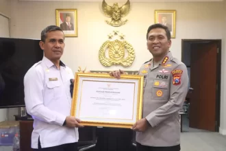 Kepala Kantor Imigrasi Kelas I TPI Surabaya, Agus Winarto menyerahkan penghargaan dari Menteri Imigrasi dan Pemasyarakatan Kepada Kapolresta Kombespol, Kombespol Christian Tobing.