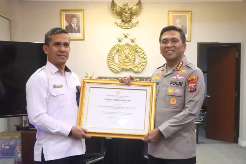 Kepala Kantor Imigrasi Kelas I TPI Surabaya, Agus Winarto menyerahkan penghargaan dari Menteri Imigrasi dan Pemasyarakatan Kepada Kapolresta Kombespol, Kombespol Christian Tobing.