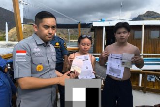 Adithia P Barus, Kepala Bidang Penegakan Hukum Keimigrasian dan Kepatuhan Internal, menunjukkan dokumen orang asing yang diamankan dari perairan