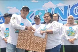 Chandra, pembina Askring Kantor Club memberikan tali Asih kepada pengurus panti yang diundang dalam kegiatan ulang tahun ke-12.