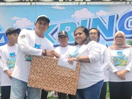 Chandra, pembina Askring Kantor Club memberikan tali Asih kepada pengurus panti yang diundang dalam kegiatan ulang tahun ke-12.