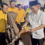 Wakil Ketua DPP Partai Golkar Adies Kadir memberikan potongan nasi tumpeng kepada warga disaksikan Ketua DPD Golkar Sidoarjo, Adam Rusydi dan anggota DPRD lainnya.