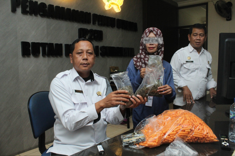 Petugas Rutan Surabaya menunjukkan barang bukti dsn terduga pelaku yang menyelundupkan barang.