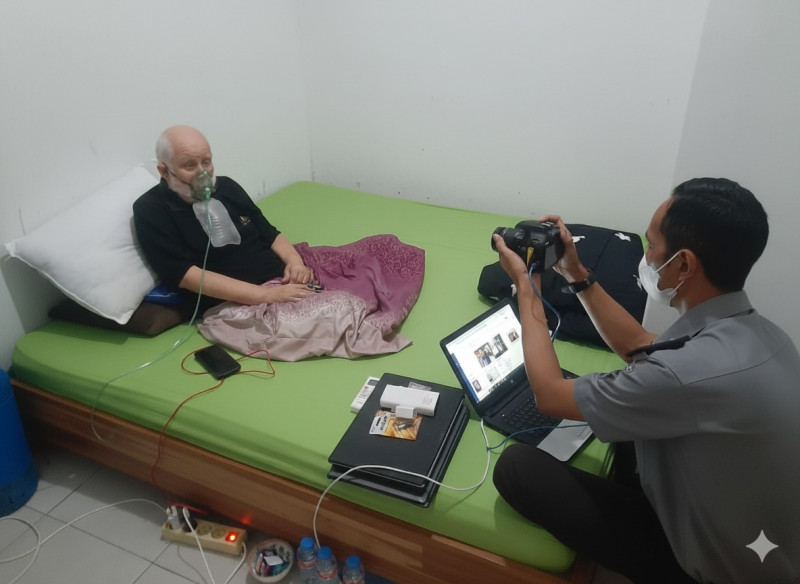 Petugas imigrasi mendatangi pemohon di rumah yang sedang sakit untuk pengambilan foto paspor.