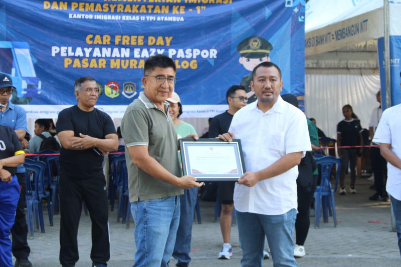 Kepala Kantor Imigrasi Atambua, Putu Agus Eka Putra (kanan) menerima penghargaan dari Bupati Belu, NTT.
