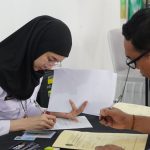 Petugas imigrasi melayani permohonan paspor.