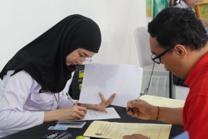 Petugas imigrasi melayani permohonan paspor.