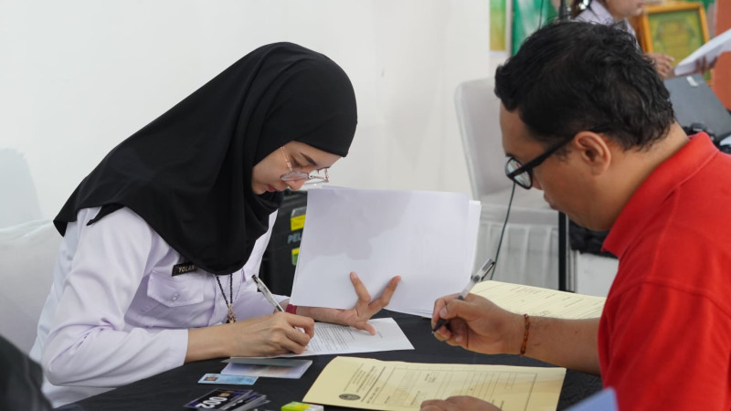 Petugas imigrasi melayani permohonan paspor.