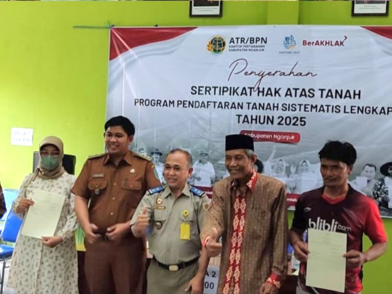 Siswanto, S.H., M.M., Ketua Adjudikasi Tim 3 PTSL, menyerahkan sertifikat PTSL kepada warga sekitar.