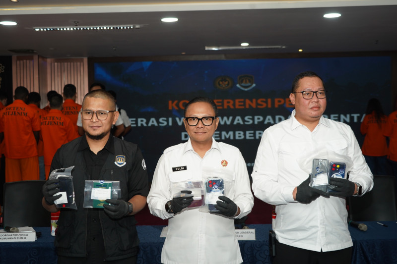 Pelaksana Tugas (Plt) Direktur Jenderal Imigrasi, Yuldi Yusman (tengah) menunjukkan paspor milik orang asing yang diamankan petugas imigrasi.