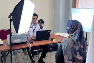 Petugas Imigrasi Semarang sedang melakukan perekaman gambar dan sidik jari pemohon paspor.