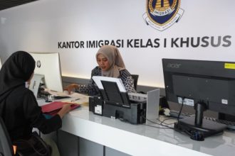 Petugas imigrasi melayani pemohon paspor rangkaian Hari Bhkati Imigrasi.
