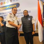 Kepala Kanwil Direktorat Jenderal Imigrasi Jatim, Novianto Sulastono, menyematkan rompi kepada salah satu anggota Forkopdensi dalan giat FGD di hotel Surabaya.