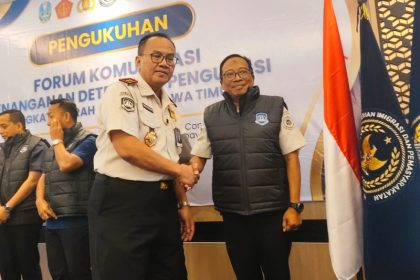 Kepala Kanwil Direktorat Jenderal Imigrasi Jatim, Novianto Sulastono, menyematkan rompi kepada salah satu anggota Forkopdensi dalan giat FGD di hotel Surabaya.