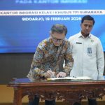 Direktur Visa dan Dokumen Perjalanan Ditjen Imigrasi, Eko Budianto (kanan), menyaksikan Direktur Konsuler Kementerian Luar Negeri, Akio Tamala, menandatangani kerja sama pilot project nasional pengambilan data biometrik paspor dinas.