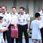 Kepala Kantor Imigrasi Kediri, Antonius Frizky Saniscara Cahya Putra, mendampingi Kepala Kanwil Ditjen Imigrasi Jawa Timur, Novianto Sulastono, saat menyerahkan bingkisan kepada anak yatim piatu usai kegiatan evaluasi kinerja.