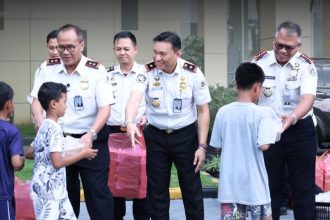 Kepala Kantor Imigrasi Kediri, Antonius Frizky Saniscara Cahya Putra, mendampingi Kepala Kanwil Ditjen Imigrasi Jawa Timur, Novianto Sulastono, saat menyerahkan bingkisan kepada anak yatim piatu usai kegiatan evaluasi kinerja.