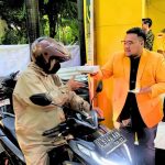 Ketua Angkatan Muda Partai Golkar (AMPG) Surabaya, Aldy Blaviandy, membagikan takjil kepada pengendara yang melintas di depan Kantor Golkar Surabaya.