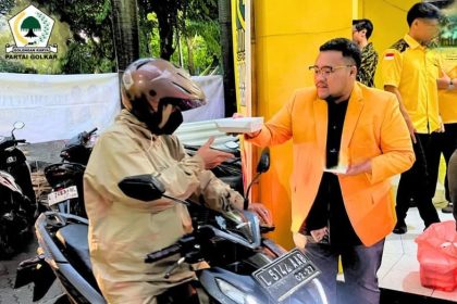 Ketua Angkatan Muda Partai Golkar (AMPG) Surabaya, Aldy Blaviandy, membagikan takjil kepada pengendara yang melintas di depan Kantor Golkar Surabaya.