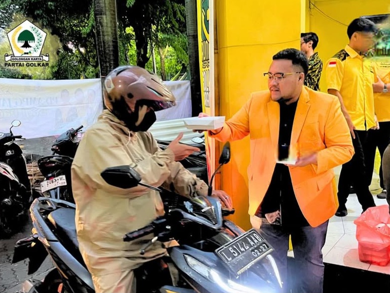 Ketua Angkatan Muda Partai Golkar (AMPG) Surabaya, Aldy Blaviandy, membagikan takjil kepada pengendara yang melintas di depan Kantor Golkar Surabaya.