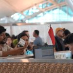 Petugas imigrasi Indonesia melayani pemeriksaan paspor milik warga negara asing.