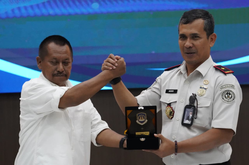 Kepala Kantor Imigrasi Surabaya, Agus Winarto (kanan), memberikan cenderamata kepada Ketua PWI Jawa Timur Lutfil Hakim.