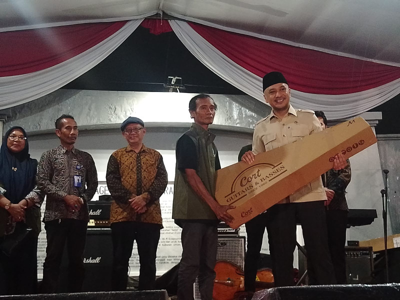 Wakil Menteri Kebudayaan Giring Ganesha memberikan bantuan alat musik kepada para pekerja seni binaan Institut Musik Jalanan.