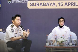 Moderator kegiatan sosialisasi TPPO, Mangatur Hadi berbincang dengan Kombespol Ganis Setyaningrum dari Polda Jatim.
