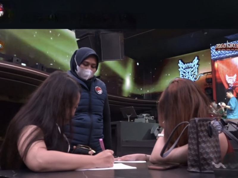 Petugas dari Ditreskoba Polda Jatim sedang memeriksa dua wanita pengunjung Diskotek Kowloon di Jalan Pemuda, Surabaya, semalam.