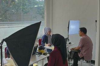 Petugas Imigrasi Semarang sedang melakukan pengambilan foto biometrik pemohon paspor.