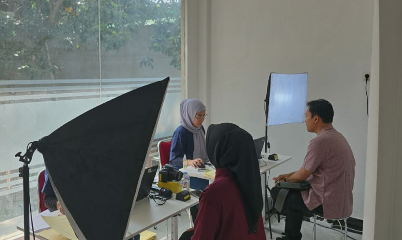 Petugas Imigrasi Semarang sedang melakukan pengambilan foto biometrik pemohon paspor.