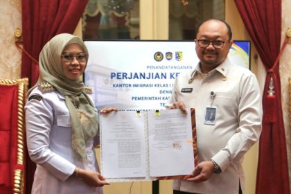 Bupati Demak Hj Eisti’anah bersama Kepala Kantor Imigrasi Kelas I Khusus TPI Semarang, Ari Widodo menunjukkan perjanjian kerja sama.