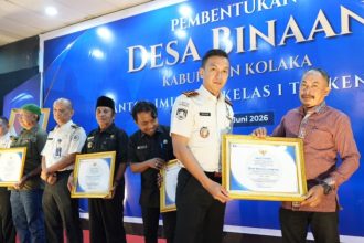 Kepala Kantor Imigrasi Kelas I TPI Kendari, Muhammad Novrian Jaya, memberikan piagam penghargaan kepada perwakilan desa binaan Imigrasi.