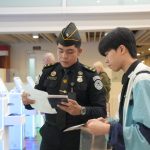 Petugas imigrasi mengarahkan penumpang melakui autogate.