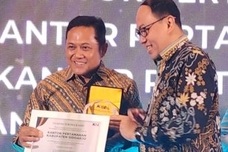 Kepala Kantor Pertanahan Kabupaten Sidoarjo, Nursuliantoro (kiri), menunjukkan penghargaan yang diberikan oleh Deputy Director PT KAI, Mohamad Nurul Huda Dwi Santoso, dalam acara yang digelar di Hotel Royal Ambarukmo, Yogyakarta.