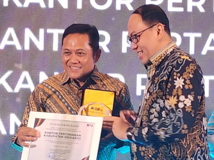 Kepala Kantor Pertanahan Kabupaten Sidoarjo, Nursuliantoro (kiri), menunjukkan penghargaan yang diberikan oleh Deputy Director PT KAI, Mohamad Nurul Huda Dwi Santoso, dalam acara yang digelar di Hotel Royal Ambarukmo, Yogyakarta.
