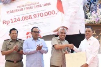 Kakanwil BPN Jatim Muhammad Naim memberikan sertifikat tanah aset milik Pemkot Surabaya kepada Kepala Kejaksaan Tinggi (Kejati) Jatim Abdul Qohar.